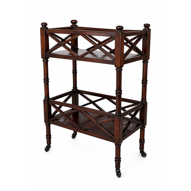 A classic two-tier side table in a rich Plantation Cherry finish, featuring elegant crisscross fretwork and turned legs...