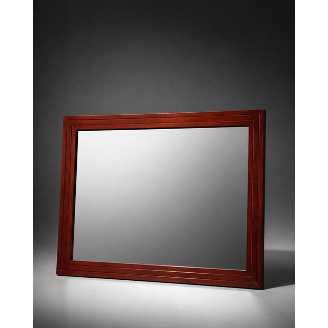 Large rectangular wall mirror featuring a reddish-brown wood frame with a classic stepped trim design. The piece has a...