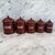 A charming set of five French enamel kitchen canisters in a rich reddish brown finish with crisp white lettering and...
