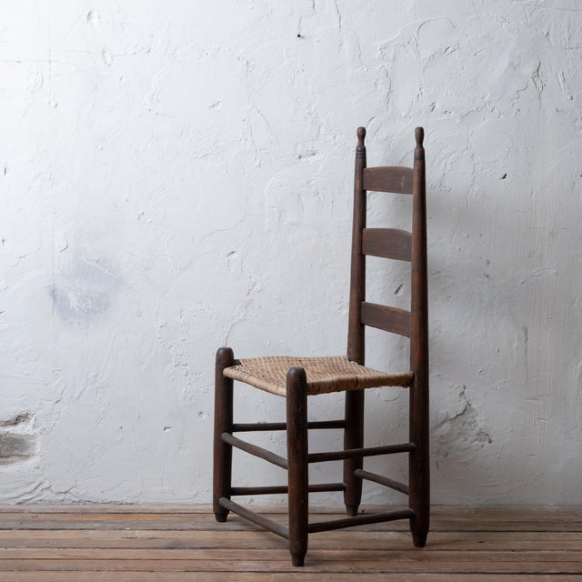 An American three slat ladder back chair with cane seat, circa 1800. 18 ¾ inches wide by 14 ¾ inches deep by 38 ¼ inches...