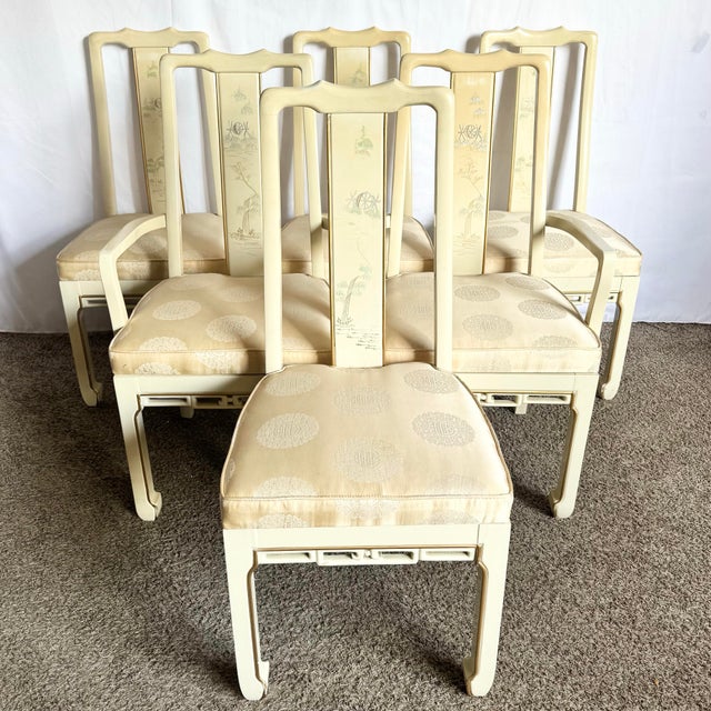A graceful set of six vintage Chinese dining chairs, finished in a soft cream lacquer and adorned with delicate hand-...
