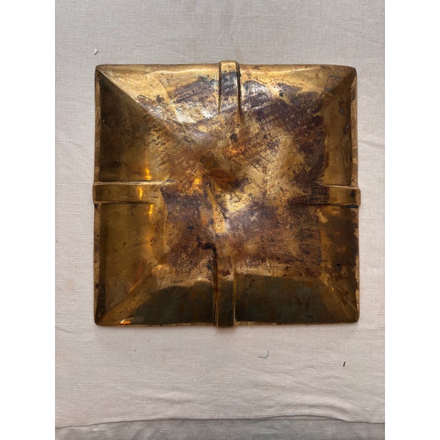Mid-century brass vide-poche plate handcrafted. The centerpiece has a hammered, geometric surface with a pyramid center....