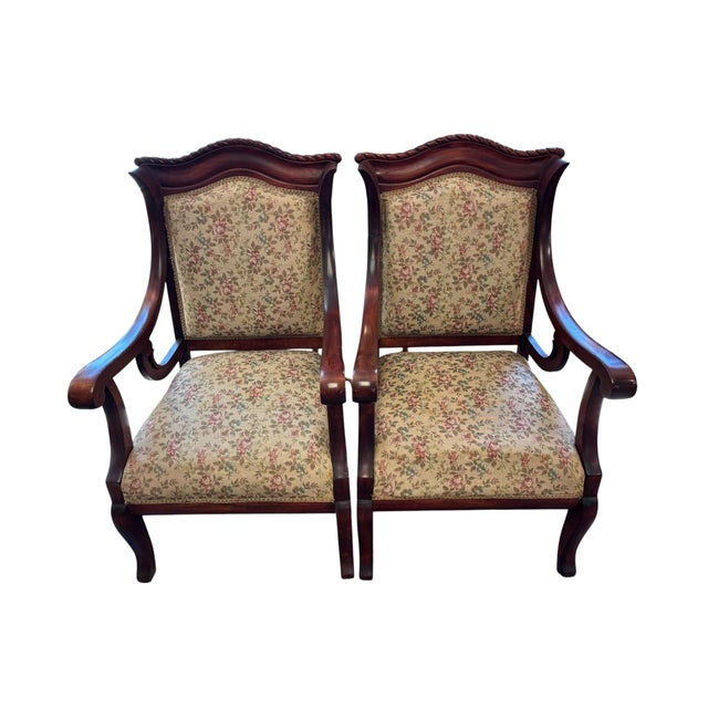 An elegant pair of French Provincial style mahogany armchairs featuring graceful cabriole legs, carved serpentine crest...