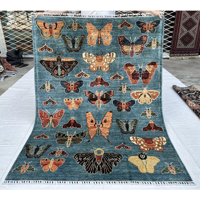 A captivating hand-knotted pictorial rug featuring an exquisite collection of over twenty individually rendered butterfly...
