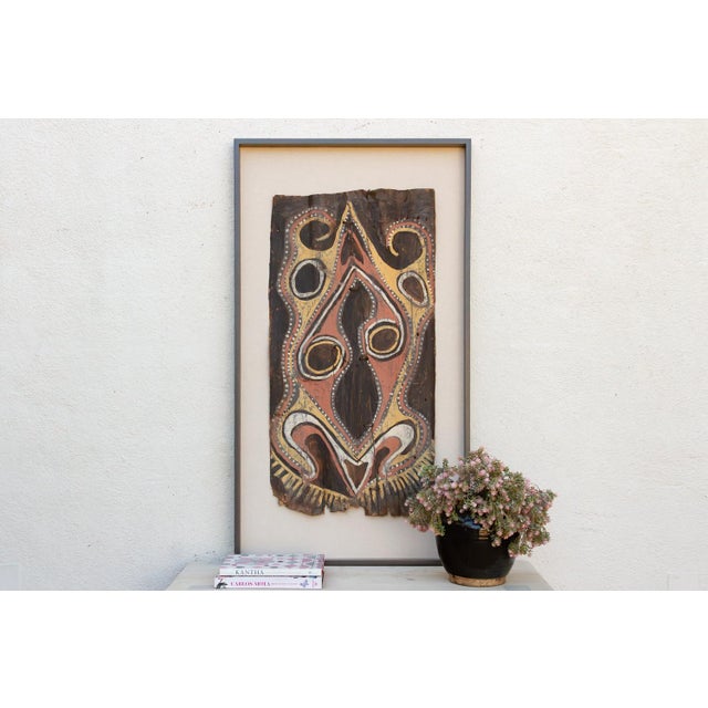 A tribal-art bark painting from Papua New Guinea, dating to the mid 20th century and framed for the wall. Bark paintings...