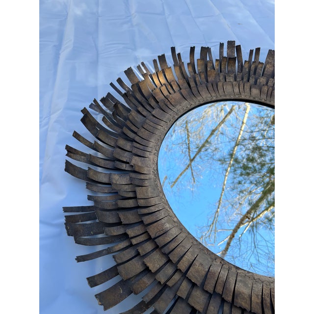 A single round mirror with “eyelash” style metal frame in the manner of Curtis Jere.