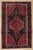 Antique hand-knotted rug from the Tuiserkan region of western Iran, featuring a bold elongated medallion design set on a...