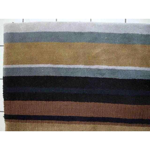 Vintage handmade Indian striped rug in blue, purple and different shades of brown. Each line of the rug made in different...