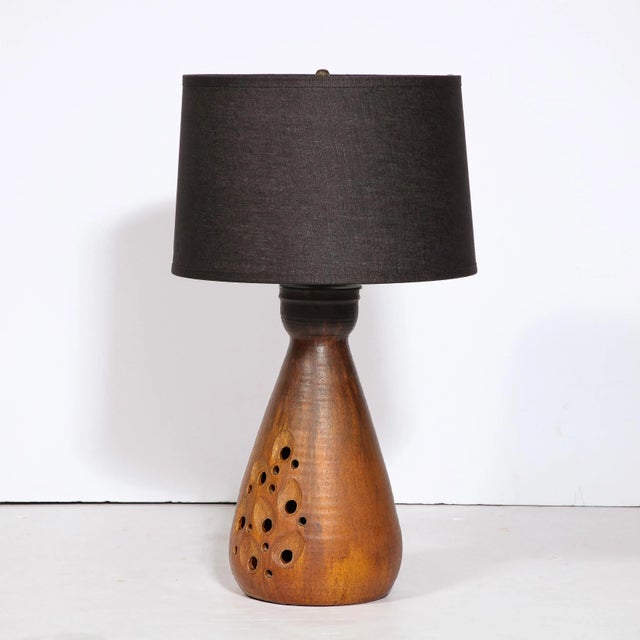 This elegant and sophisticated Mid Century Modern ceramic table lamp was realized in France, circa 1960. It features a...