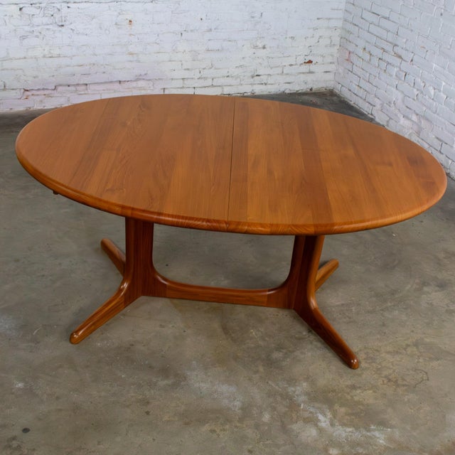 Gorgeous vintage Scandinavian Modern teak expanding oval dining table composed of a solid teak frame with 2 leaves...