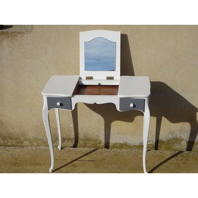 A 1970s dressing table in solid wood, restored and painted white. The central section opens to reveal a mirror on a...