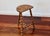 Antique tripod stool in turned wood, characterized by its twisted legs connected by a carved stretcher that emphasizes its...