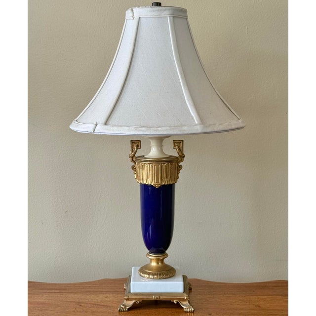An elegant and upscale French Sèvres style table lamp of cobalt blue and white porcelain and gold touches with the look of...