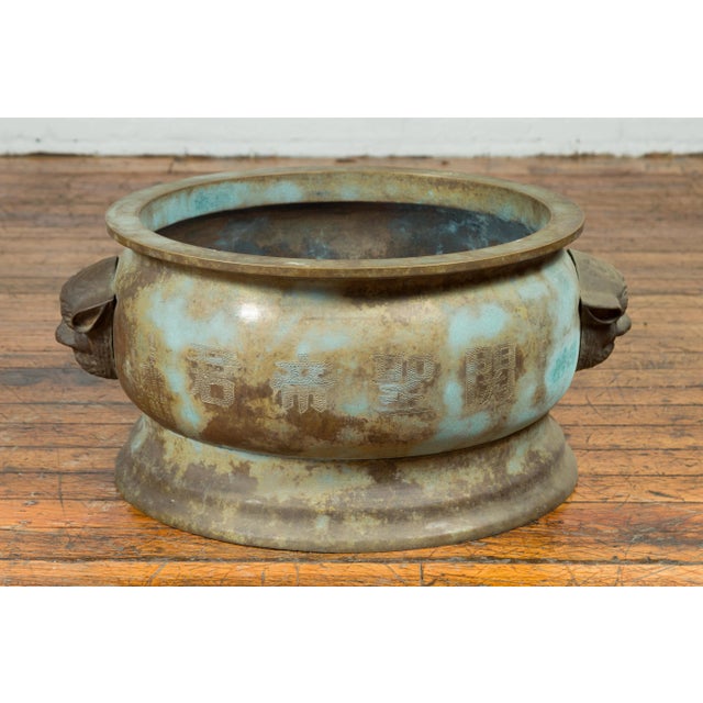 An antique Chinese bronze oversized planter from the 19th century, with mythical animal handles. Crafted in China during...