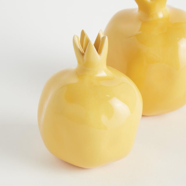 With a bright yellow glaze, uneven texture and organic form, these little pomegranate bud vases are simple and raw....