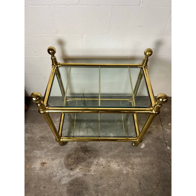 Fantastic vintage two-tier brass and glass side table, often referred to as a bar cart or serving trolley. This specific...