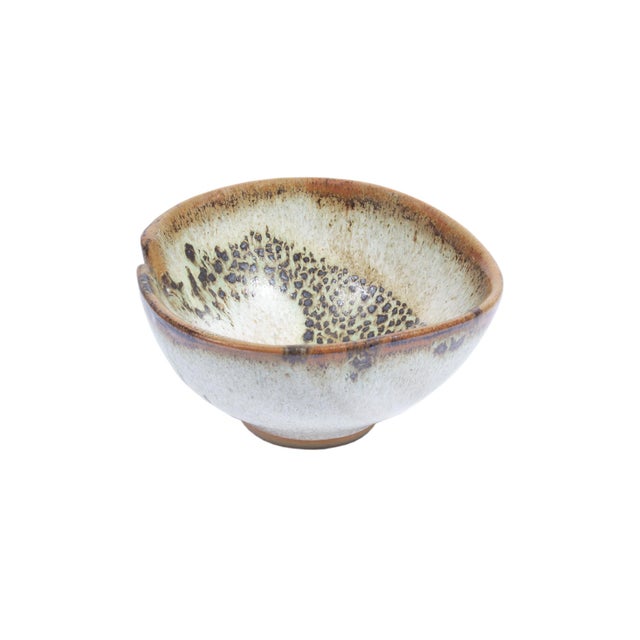 A studio pottery bowl by the American artist Abraham Cohn (born 1925). This bowl features a brown rim with a single small...