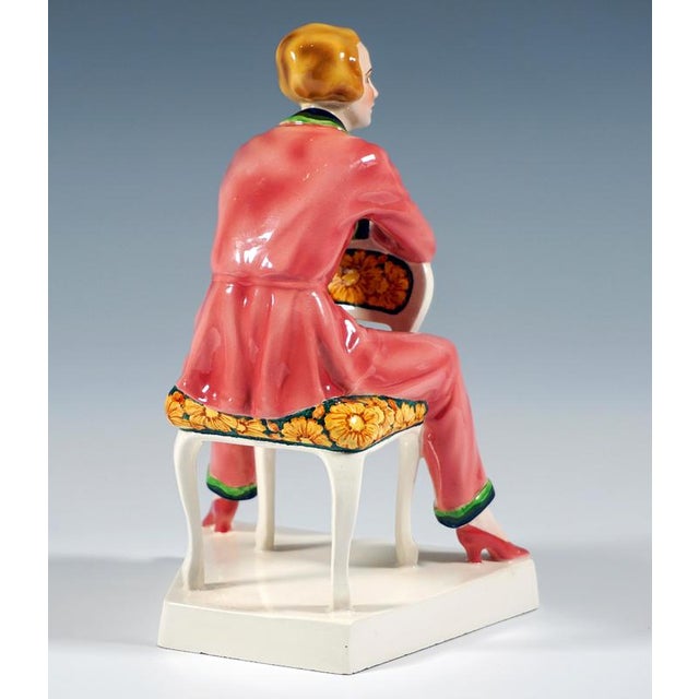 Very rare goldscheider ceramic figurine. The young lady with a blonde page-boy hair cut is wearing pink pajamas with blue-...