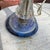 This vintage glass table lamp combines clear and cobalt hues with elegant brass accents. Its textured base and compact...