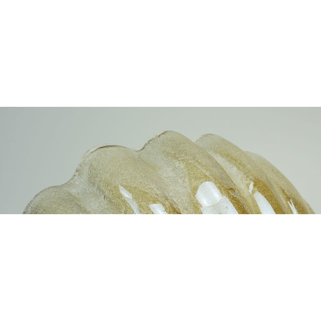 A very beautiful, large decorative wall lamp from the 1960s or 70s. The shell-shaped shade is made of lustrous glass with...