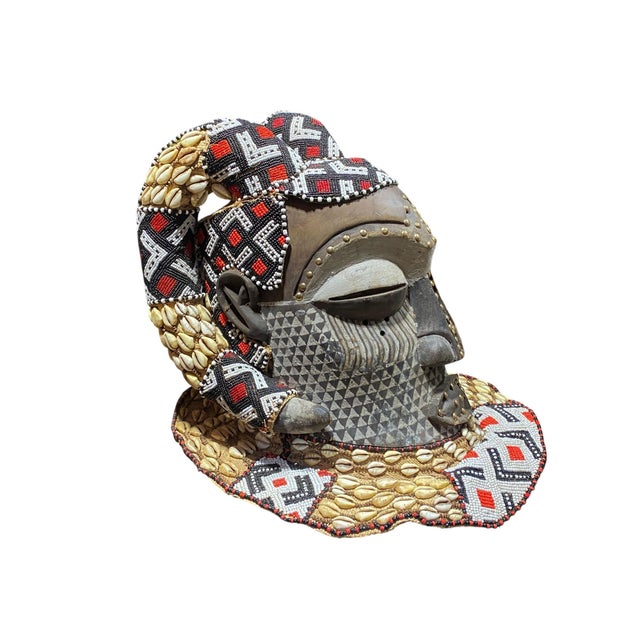 This impressive large vintage Kuba royal head mask from the Congo is crafted from wood, cloth, and raffia, adorned with...