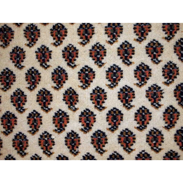 Vintage handmade Indian rug with Seraband design in white shade with rusty border. All-over design with paisley pattern....