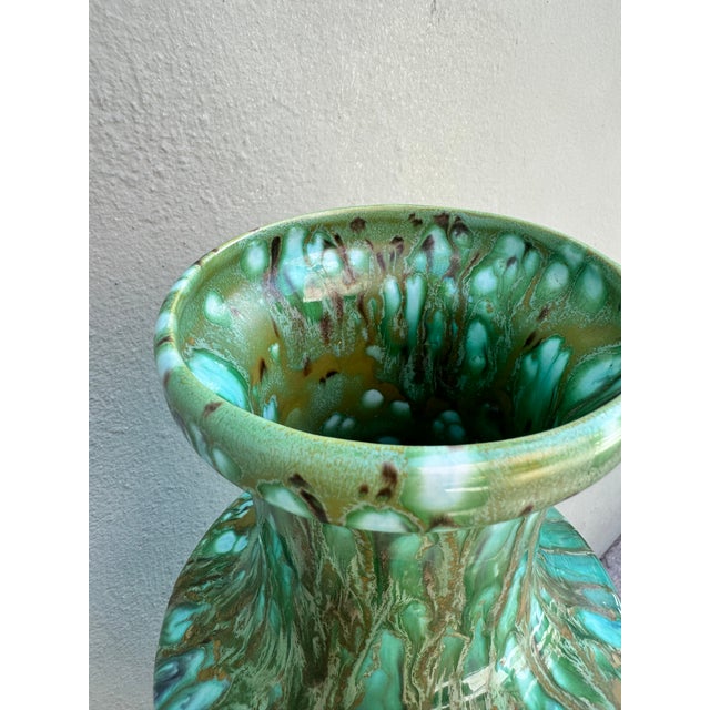 A commanding baluster-form ceramic vase glazed in a spectacular multi-layered drip finish — rich sage and emerald green...