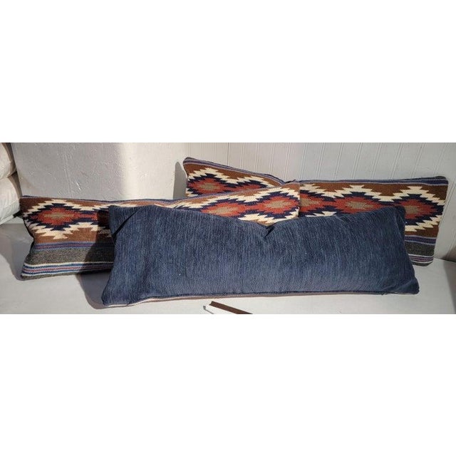 Bolster pillows collection of three. The backing is in a blue cotton linen. Sold as a group of three. Down & feather fill.