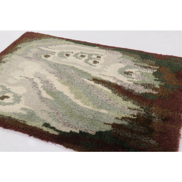 Hand-knotted in lush, high-pile wool in Sweden circa 1960-1970, this 5x7 vintage Swedish Rya rug is a bold new addition to...