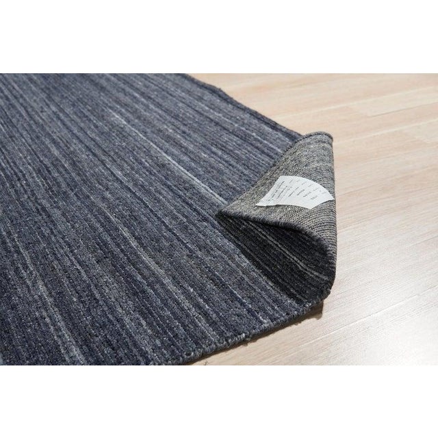 This gray wool rug features a hand knotted pile construction and serves as a versatile foundation for interior spaces....