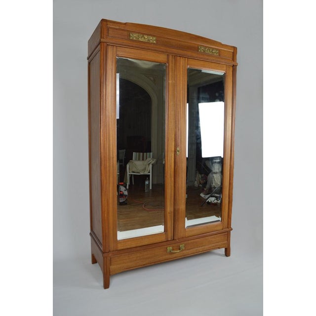 Large double-door mahogany wardrobe / cabinet with beveled mirrors. On the outside we find a large drawer and a pediment...