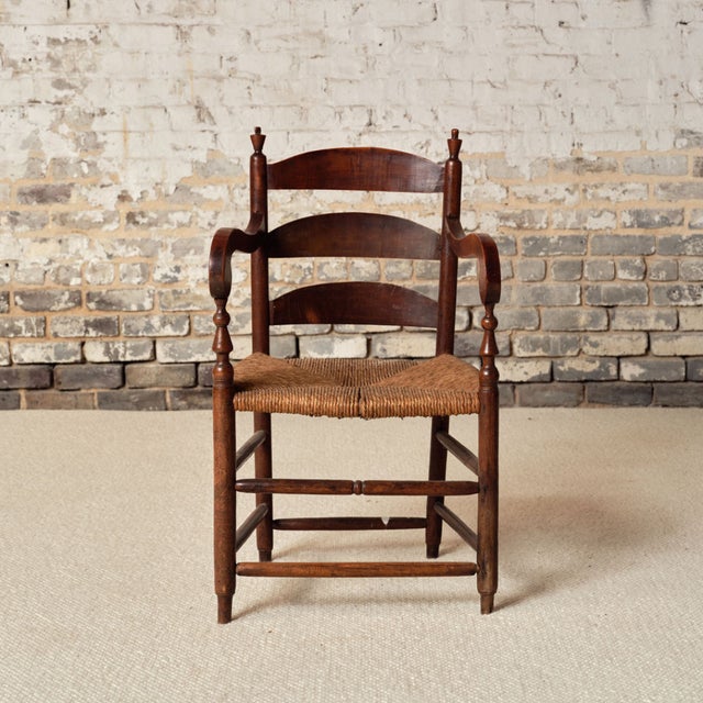 This 19th Century French Provincial oak chair features a beautifully worn rush seat, gracefully curved ladder back, and...