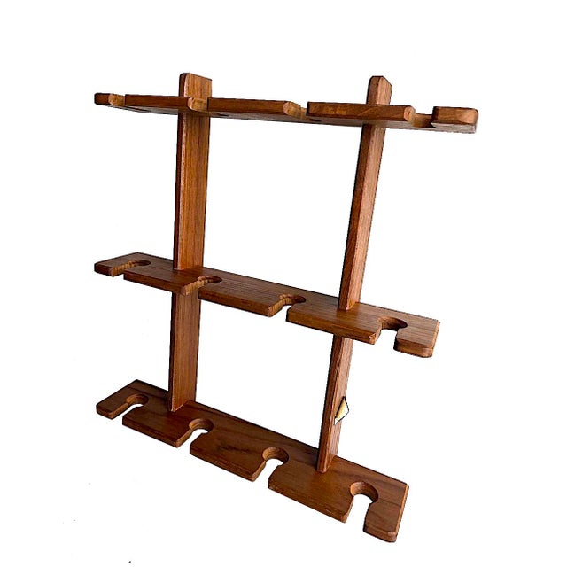 Offered is a 1970s teak wood wall mounting rack to hold wine glasses or other stem ware made by Dolphin in Thailand. It...