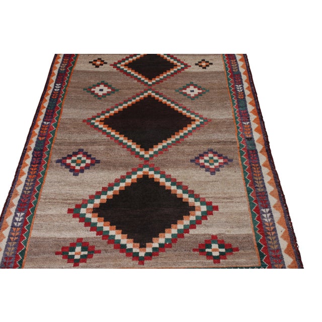 Hand-knotted in wool originating circa 1920-1930, this antique Persian rug connotes a tribal Gabbeh rug design marrying a...