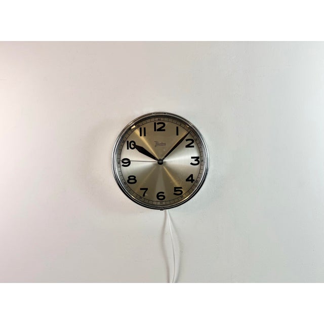This wall clock was produced by Palmtag in Germany during the 1960s. It features a silver chrome plated iron frame, a...