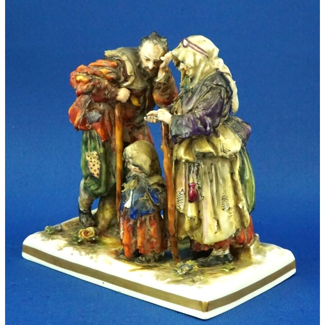 An antique polychrome and vitrified hard-paste porcelain sculpture depicting a group of two beggars and a little girl....