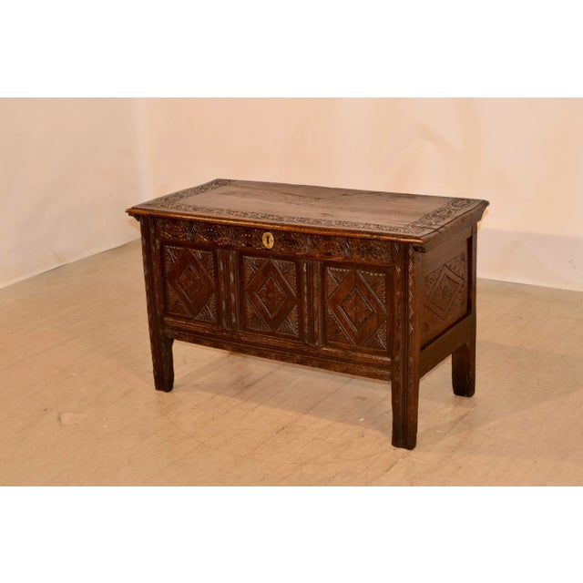 Circa 1690-1710 oak blanket chest from England with wonderful color and carving. The top has a beveled edge and is banded...