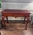 Elegant vintage mahogany console or writing table featuring beautifully carved Queen Anne–style detailing and graceful...