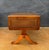 Elegant drop-leaf low table dating to the mid-20th century. The table features a rectangular top with a leather writing...