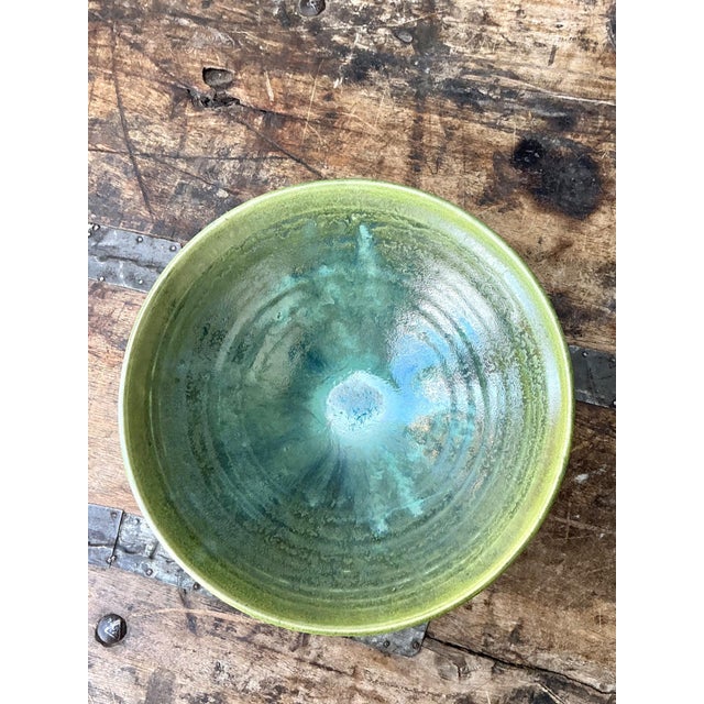 This vintage studio pottery green bowl is a compelling example of mid-20th-century artisan ceramic work, where expressive...