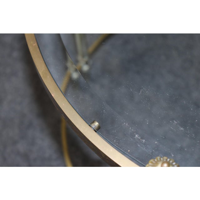 This elegant oval brass coffee table in the Maison Jansen style captures the refined balance of neoclassical Directoire...