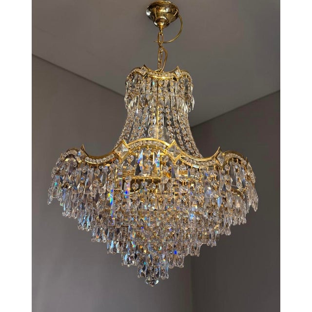 An exceptional and highly decorative monumental crystal chandelier, executed in the glamorous Hollywood Regency style and...
