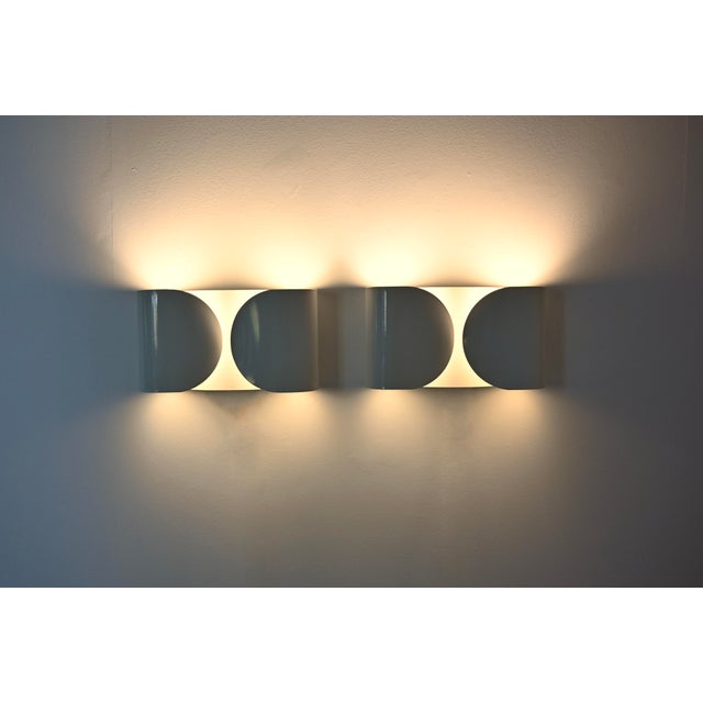 Pair of white metal wall sconces by Afra & Tobia Scarpa. Model: Foglio. Stamped Flos. Wear consistent with age and age....