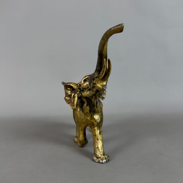 A majestic, handcrafted solid brass elephant with a raised trunk, a symbol of good luck and prosperity, dating back to the...