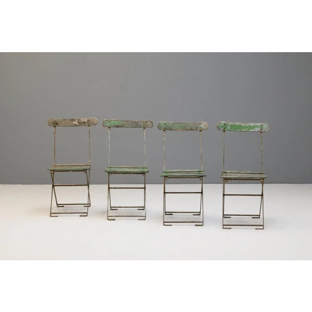 Set of four folding garden chairs in original faded paint finish. Circa 1900.