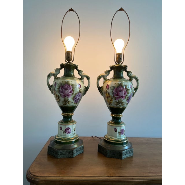 This elegant pair of antique porcelain table lamps features hand-painted floral designs in rich shades of pink, green, and...