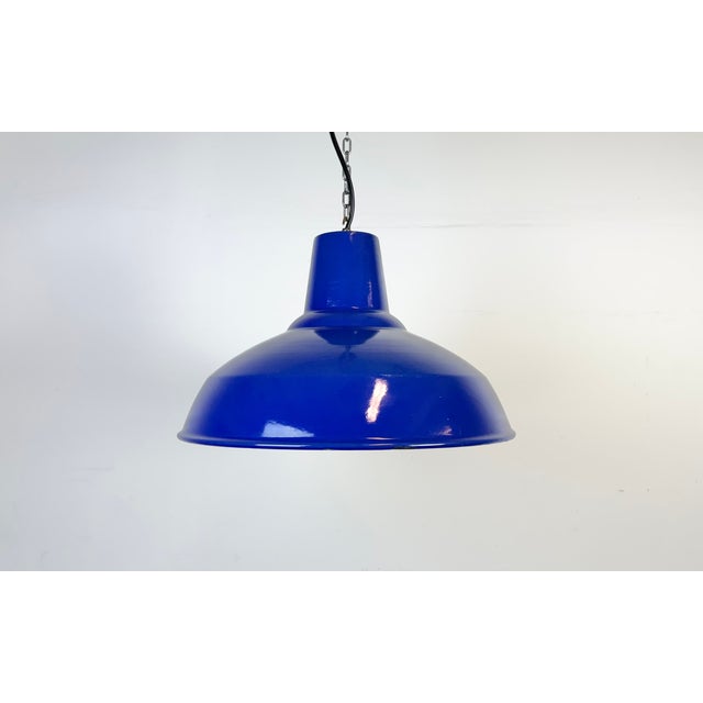 Industrial blue enamel factory pendant light made in United Kingdom during the 1960s. White enamel inside the shade. Brass...
