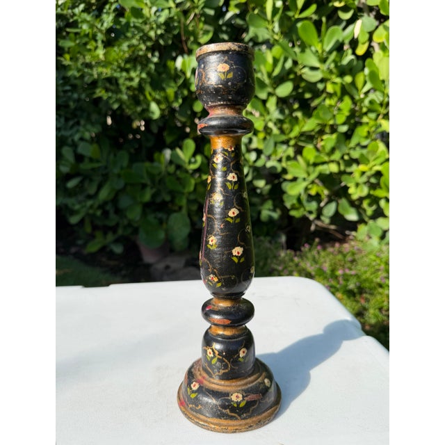 A distinctive vintage hand-painted candlestick featuring an elegant turned silhouette decorated with delicate floral...