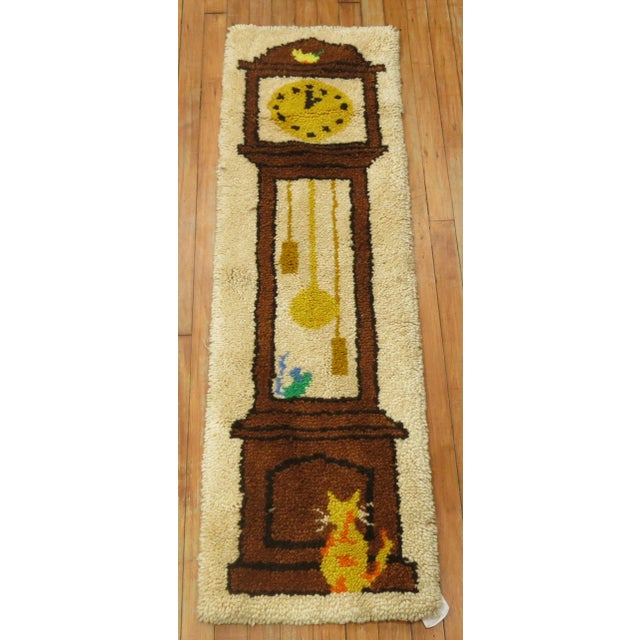 A late 20th century handmade turkish rug depicting a grandfather clock. Professionally cleaned and personally vetted. made...