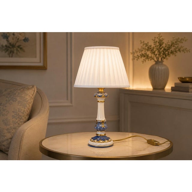A charming and elegant vintage ceramic table lamp featuring a beautifully decorated blue and white porcelain body with...